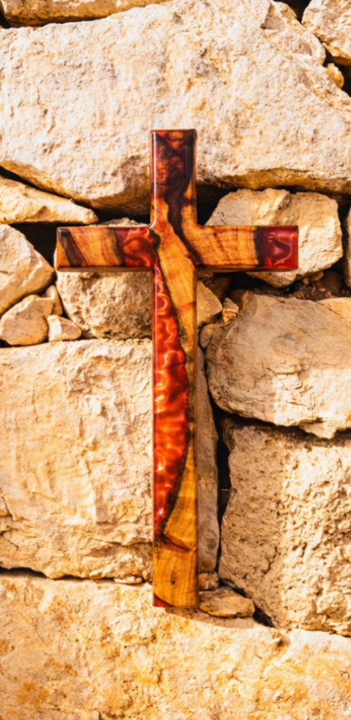 Handcrafted wooden cross with red resin inlay mounted on a stone wall
